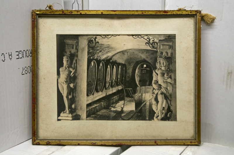 Museum: Historische Schwarz-Weiß-Aufnahme eines Weinkellers mit Holzfässern, verziert mit klassischen Skulpturen und Rundbögen.