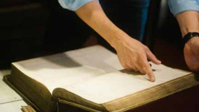 Person zeigt mit einem Finger in ein Buch